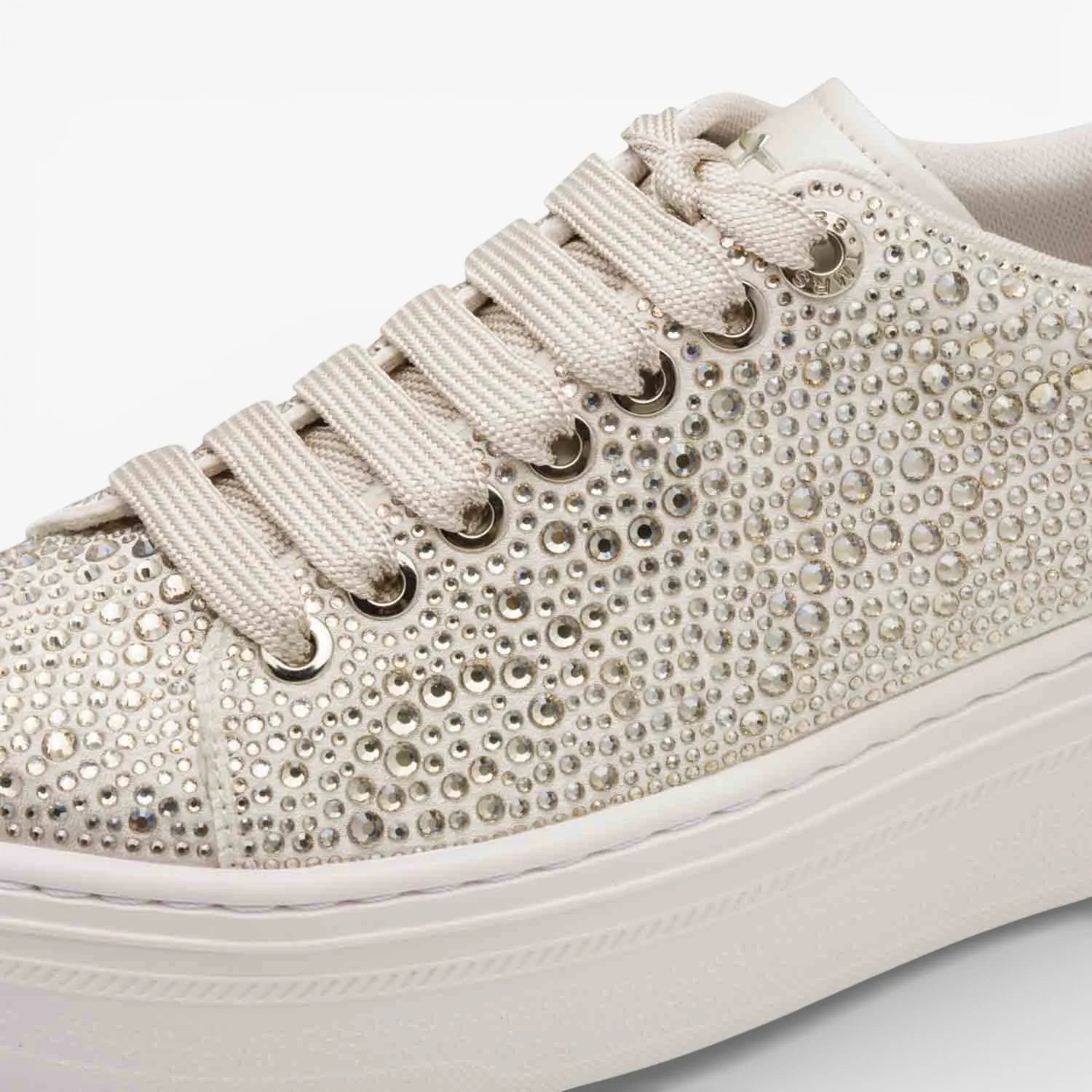 Beige sneaker with rhinestone embellishments on a white background