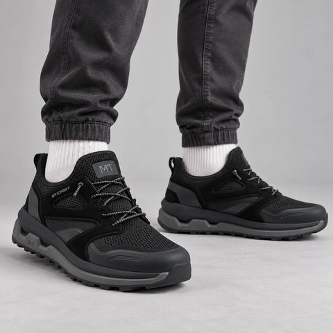 Marco Tozzi men's black MT Sport chunky trainers worn with graphite joggers and off-white socks in a grey studio.
