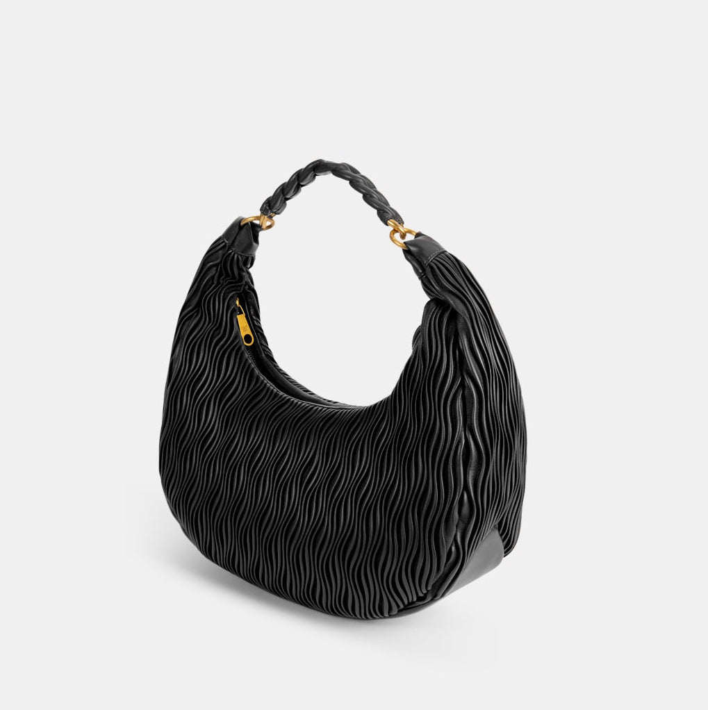 Black textured handbag with braided handle on a light gray background