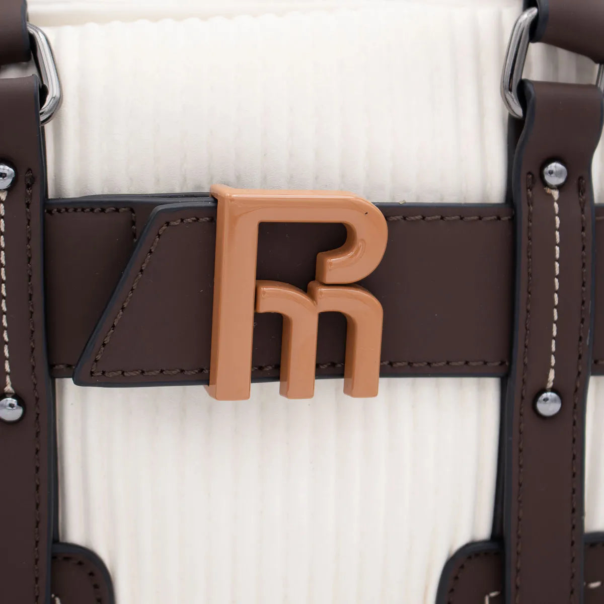 Close-up of a brown leather strap with a logo on a white background