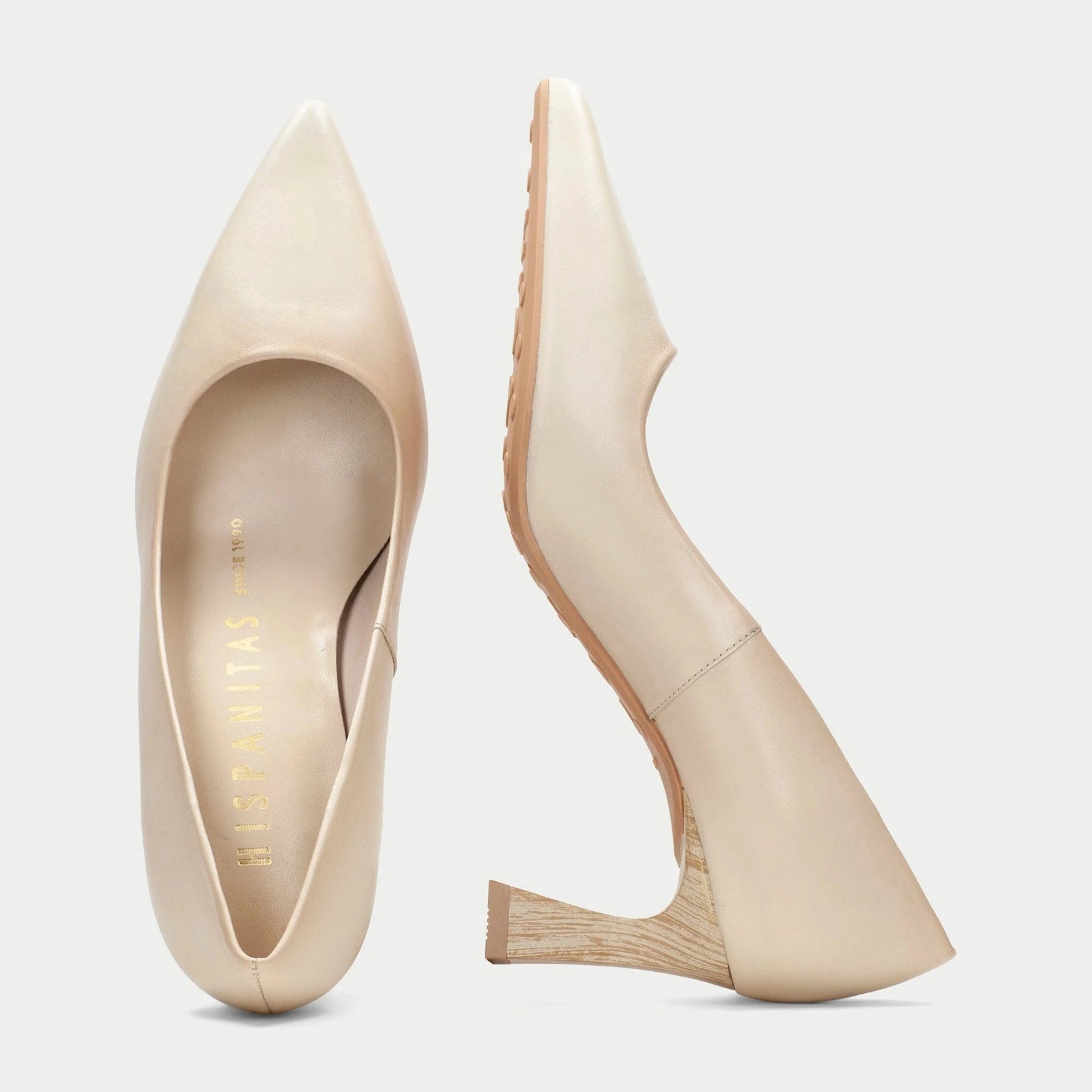 Pair of beige pointed-toe shoes on a light gray background