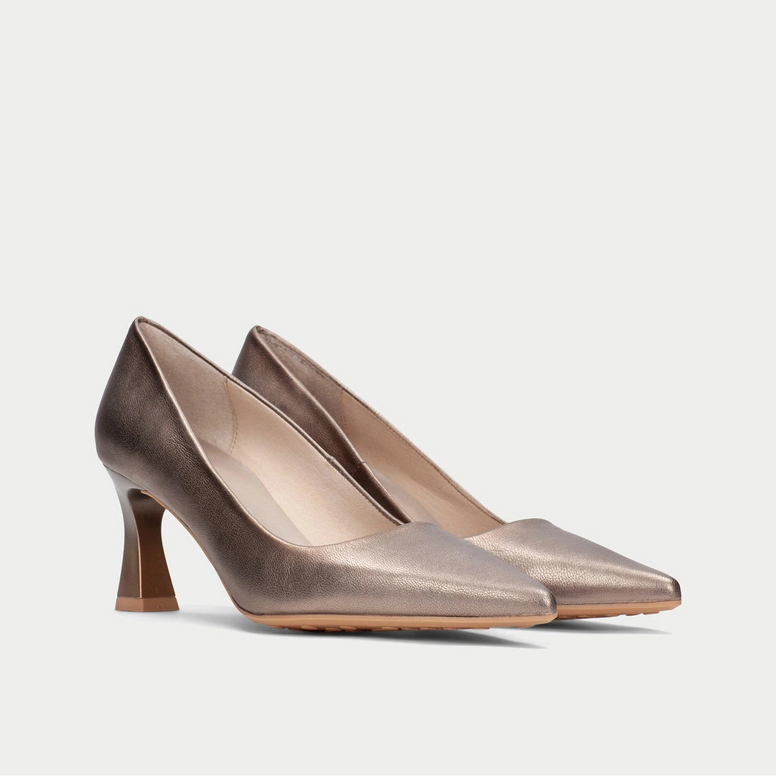 Pair of bronze high-heeled shoes on a light gray background