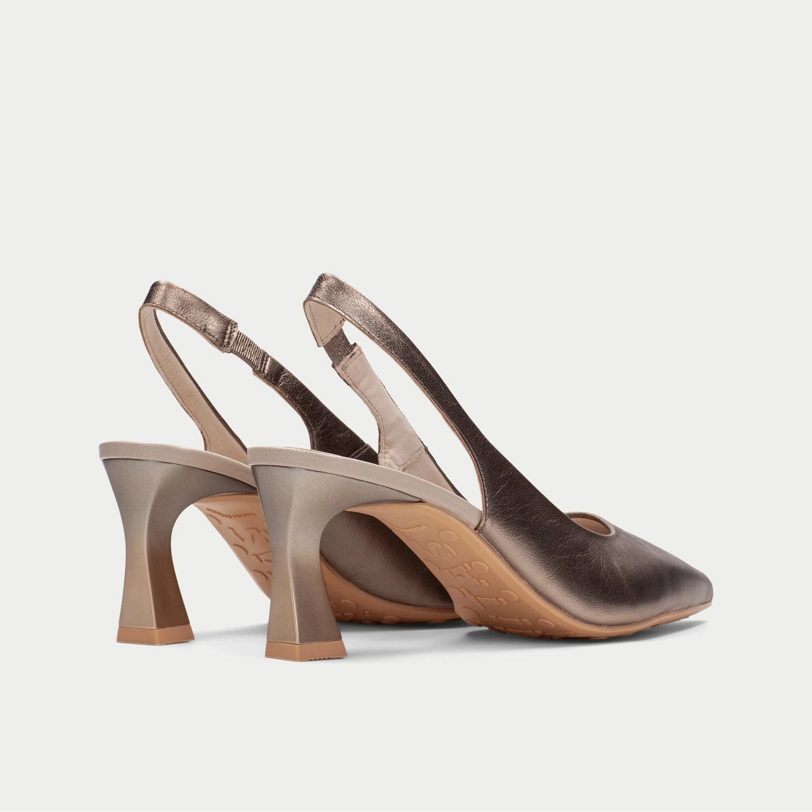 Pair of brown slingback heels on a light gray background