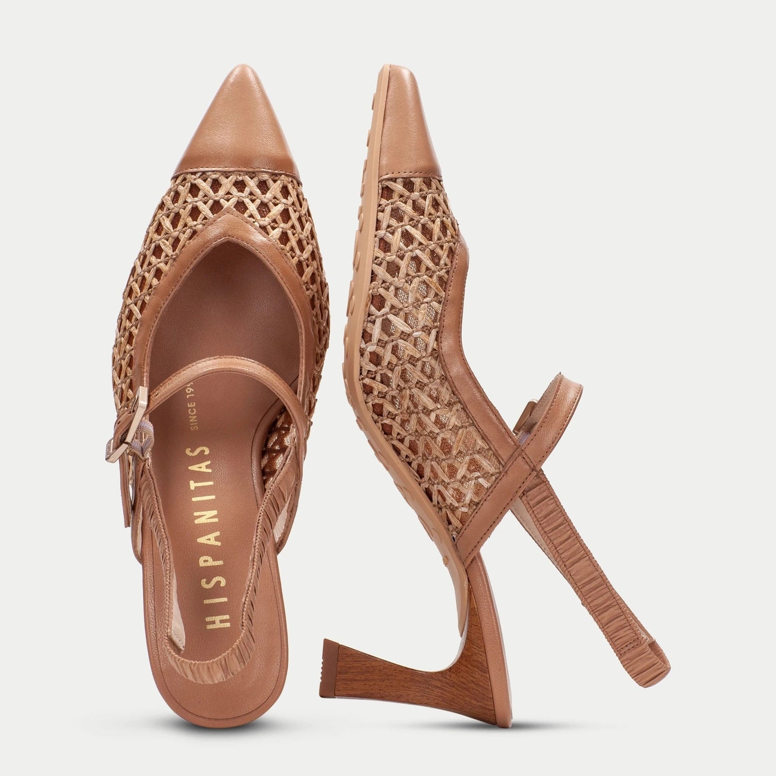 Pair of brown high-heeled shoes with detailed design on a light gray background