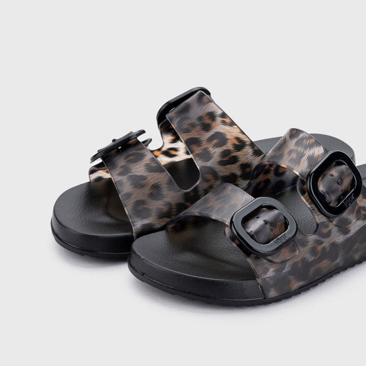Leopard print sandals with black buckles on a light gray background