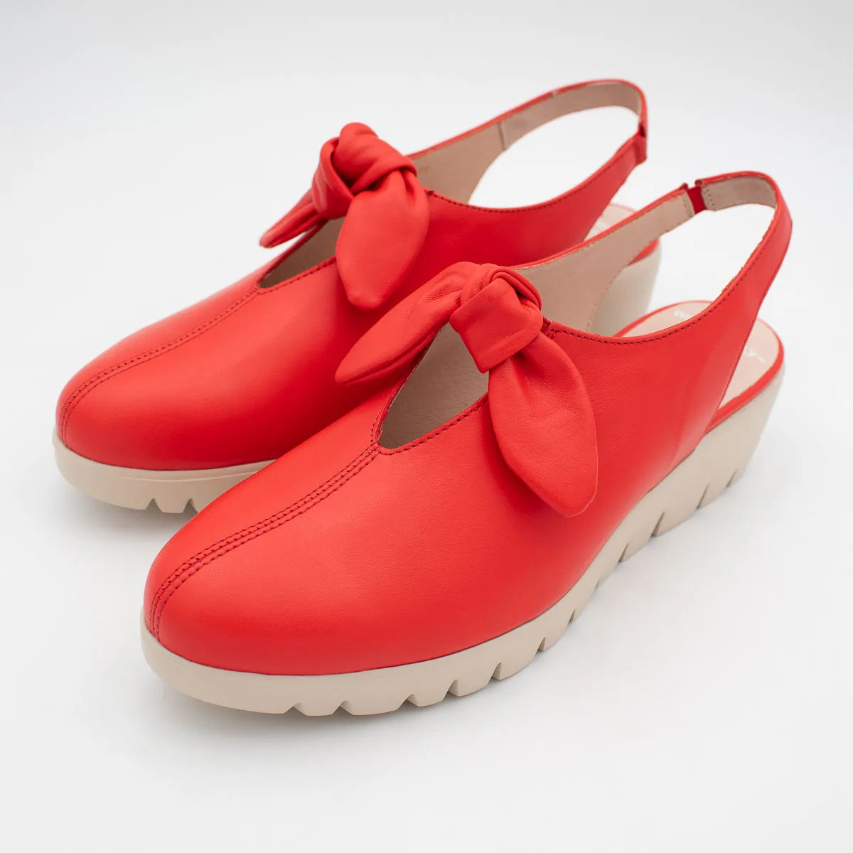 Red shoes with bow details on a white background