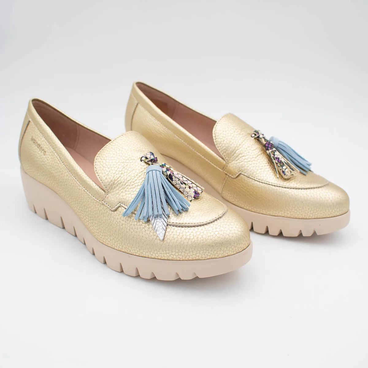Gold loafers with blue tassels on a white background