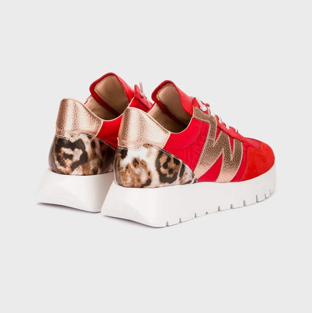 Red sneakers with leopard print accents on a light gray background