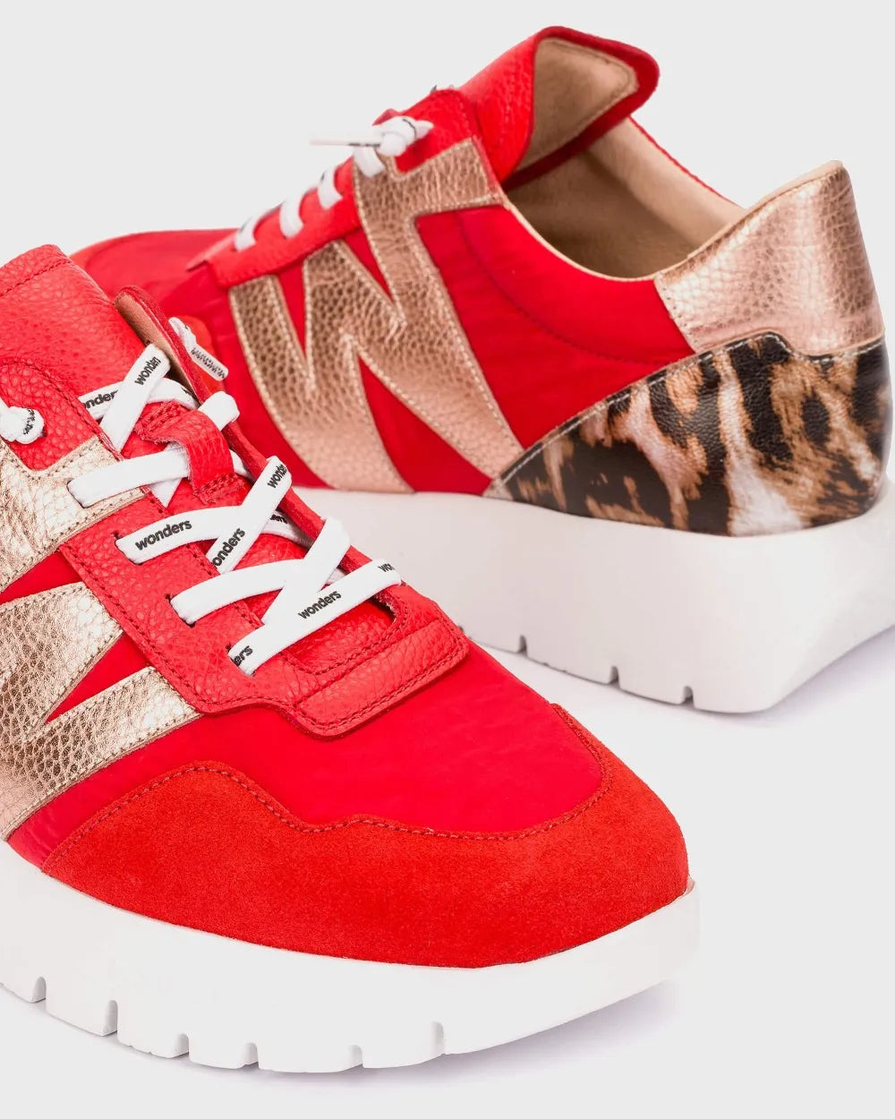Red and beige sneakers with leopard print accents on a white background