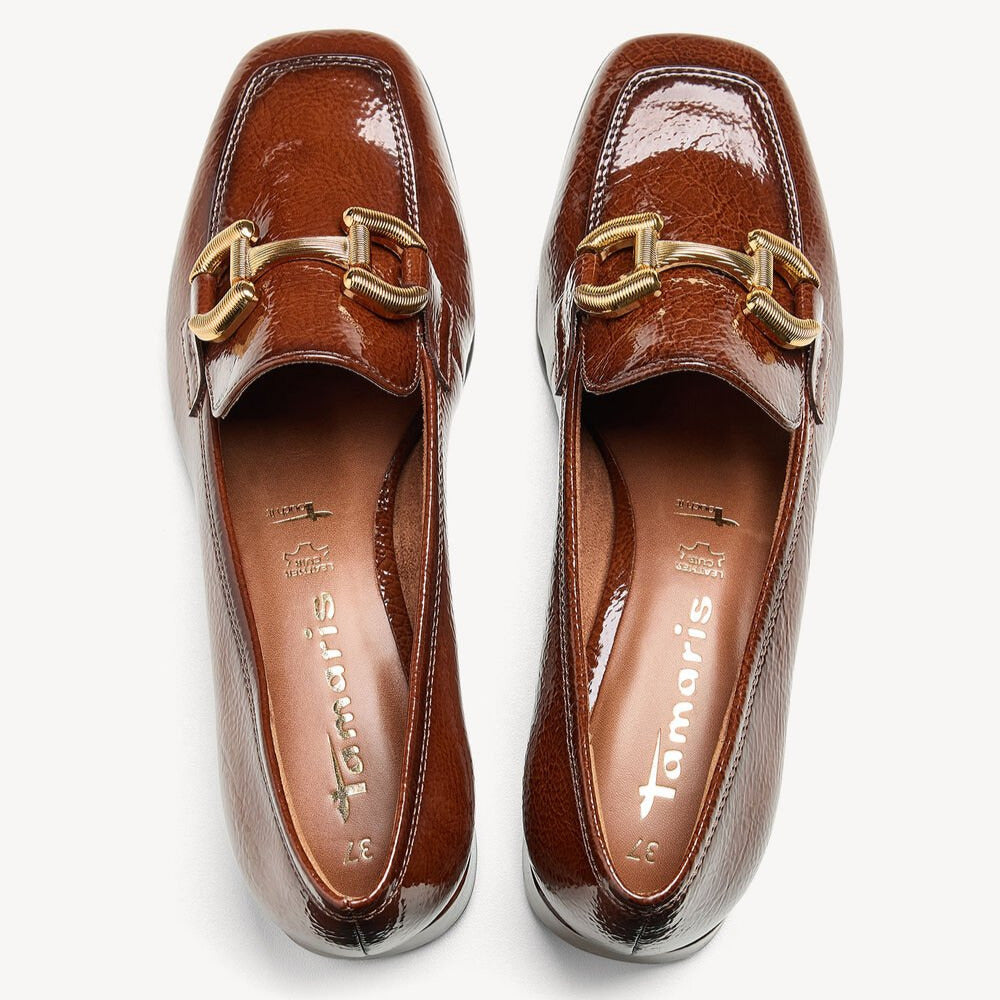 Pair of brown loafers with gold buckles on a white background