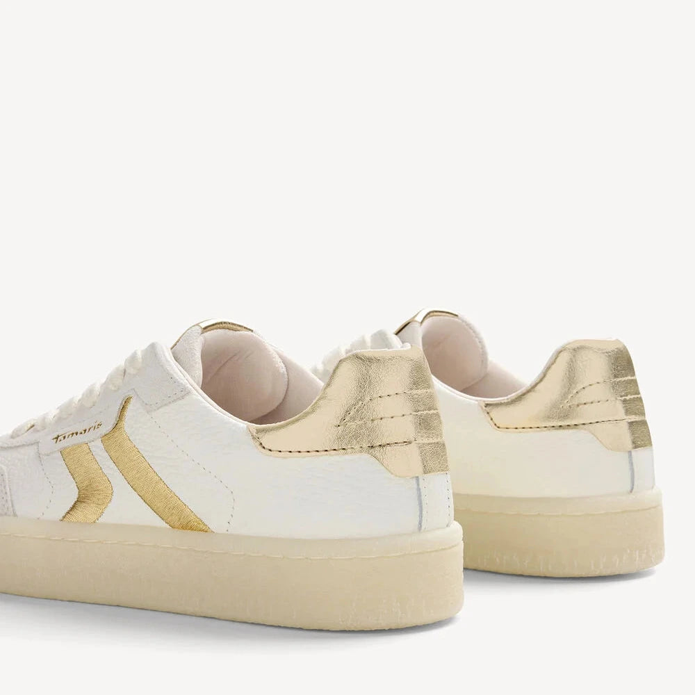 White sneakers with gold accents on a white background