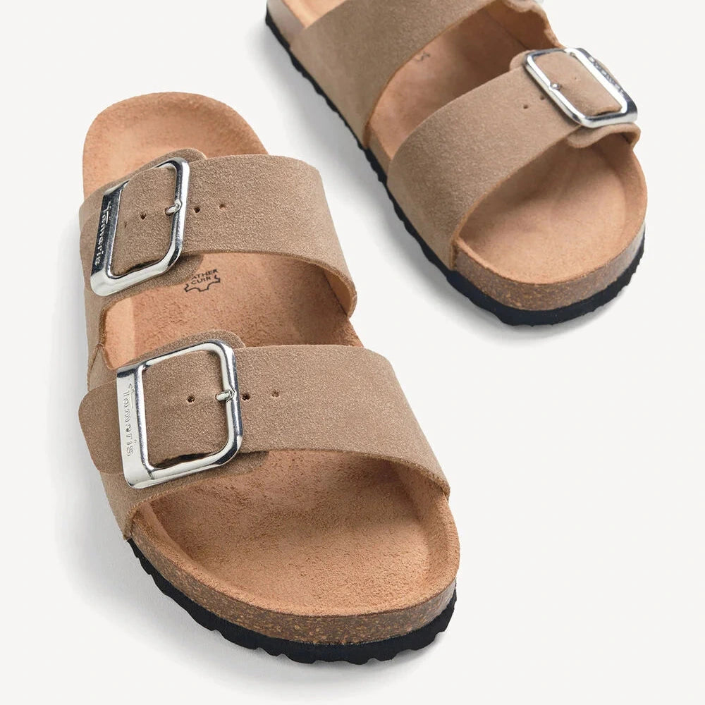 Pair of tan sandals with buckles on a white background