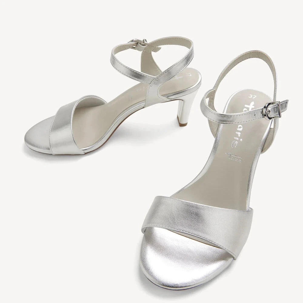 Pair of silver high-heeled sandals on a white background