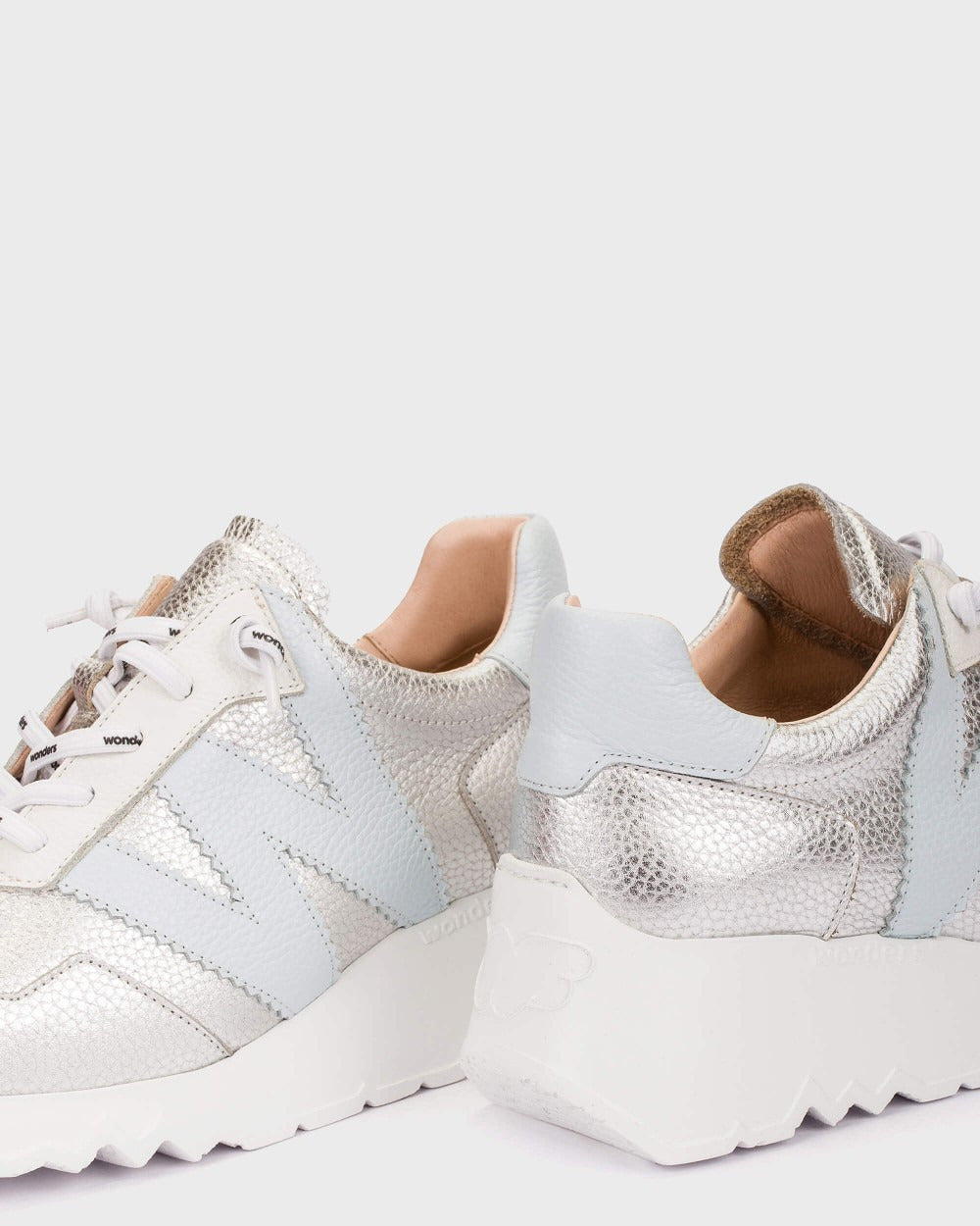 White sneakers with a textured pattern on a light gray background