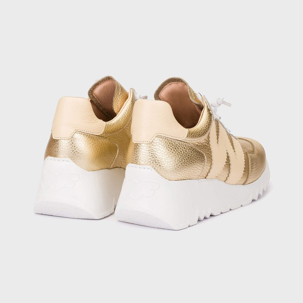 Gold and white sneakers on a light gray background