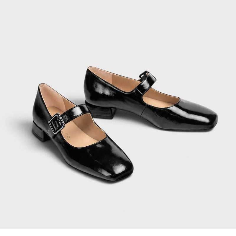 Pair of Unisa Culver black patent leather Mary Jane shoes showing square toes, buckle straps and leather interiors