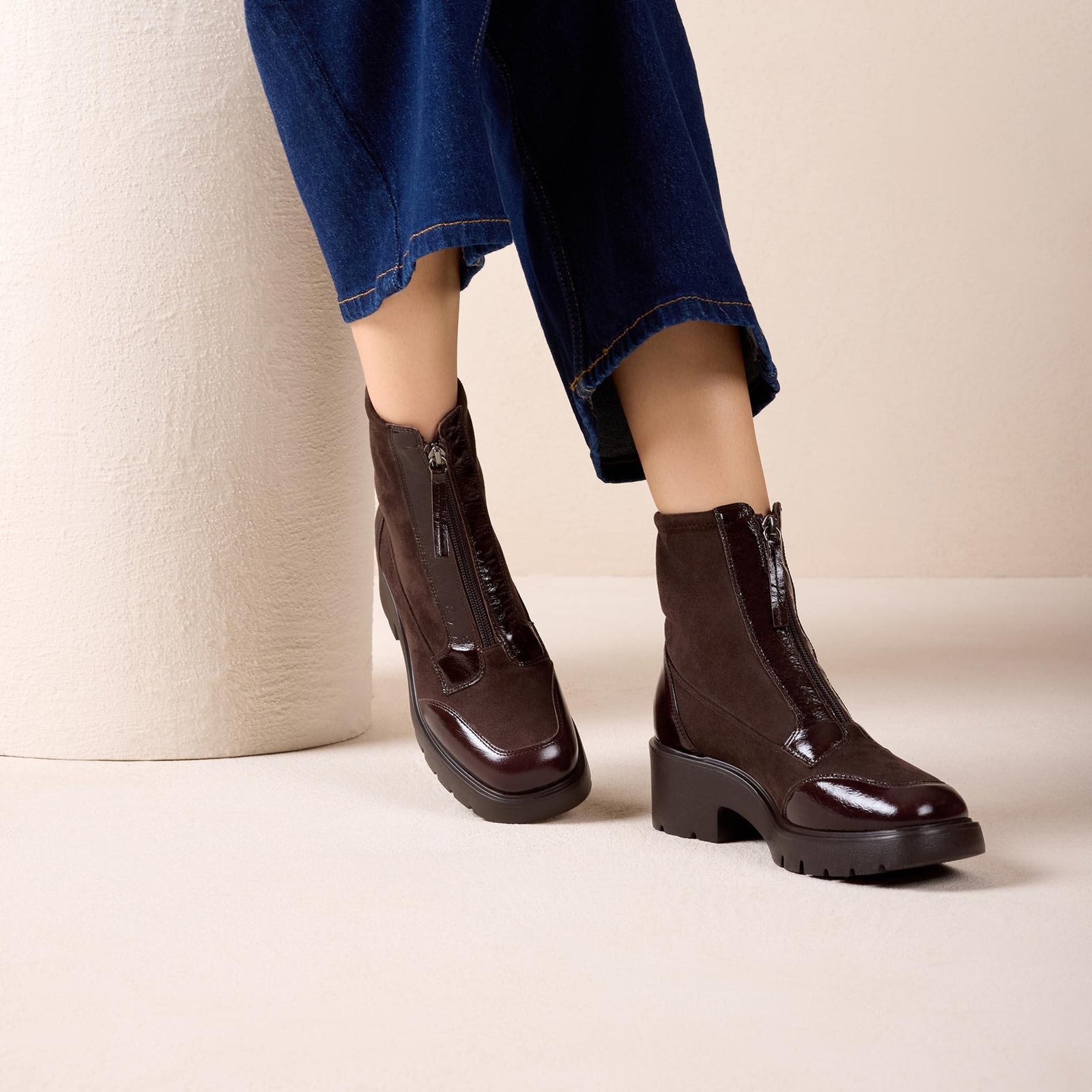 Unisa Jandro dark brown patent and stretch zip ankle boots worn with cropped navy trousers