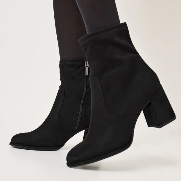 Close up of woman wearing black dressy ankle boots with tights.