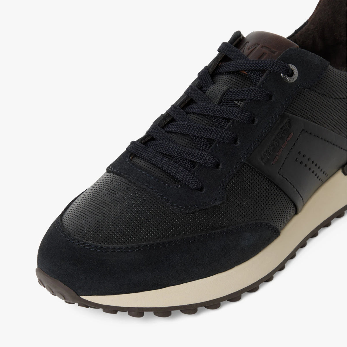 Close-up of the laces, navy leather panels and cream sole on the Marco Tozzi trainer.