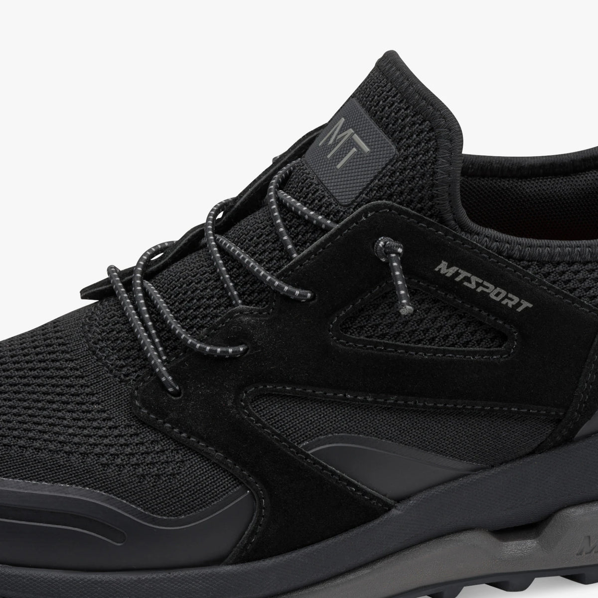 Close-up of the lacing, mesh and MT Sport branding on the black Marco Tozzi trainer.
