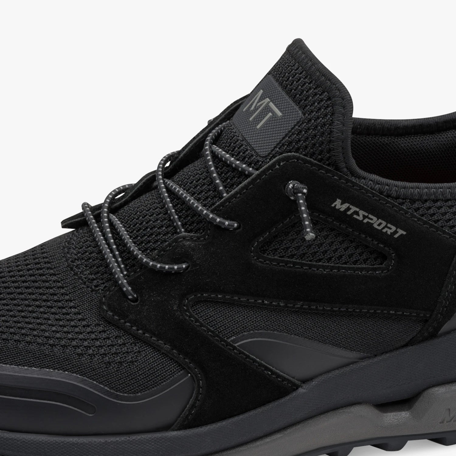 Close-up of the lacing, mesh and MT Sport branding on the black Marco Tozzi trainer.