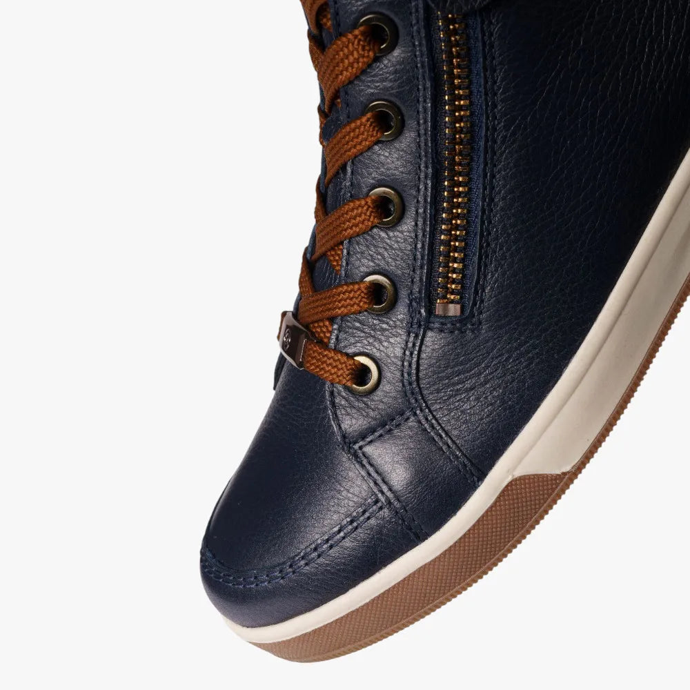 Navy blue sneaker with brown laces and sole on a white background