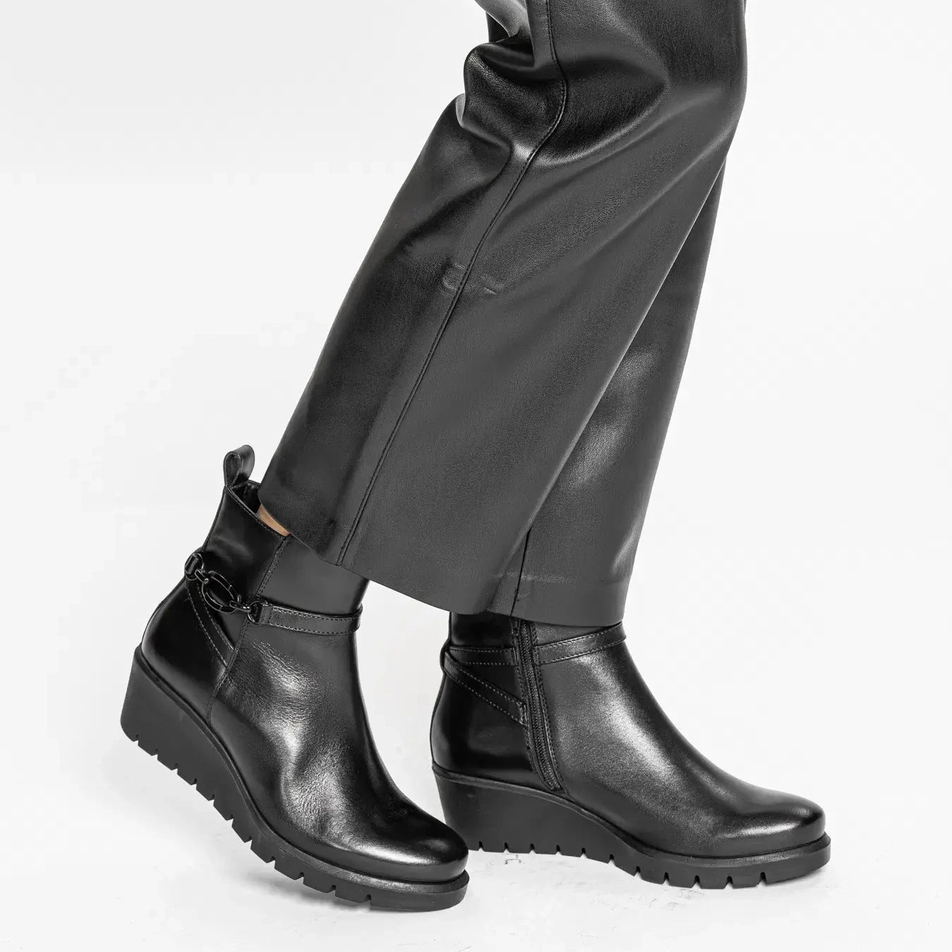 Black leather boots and pants on a white background