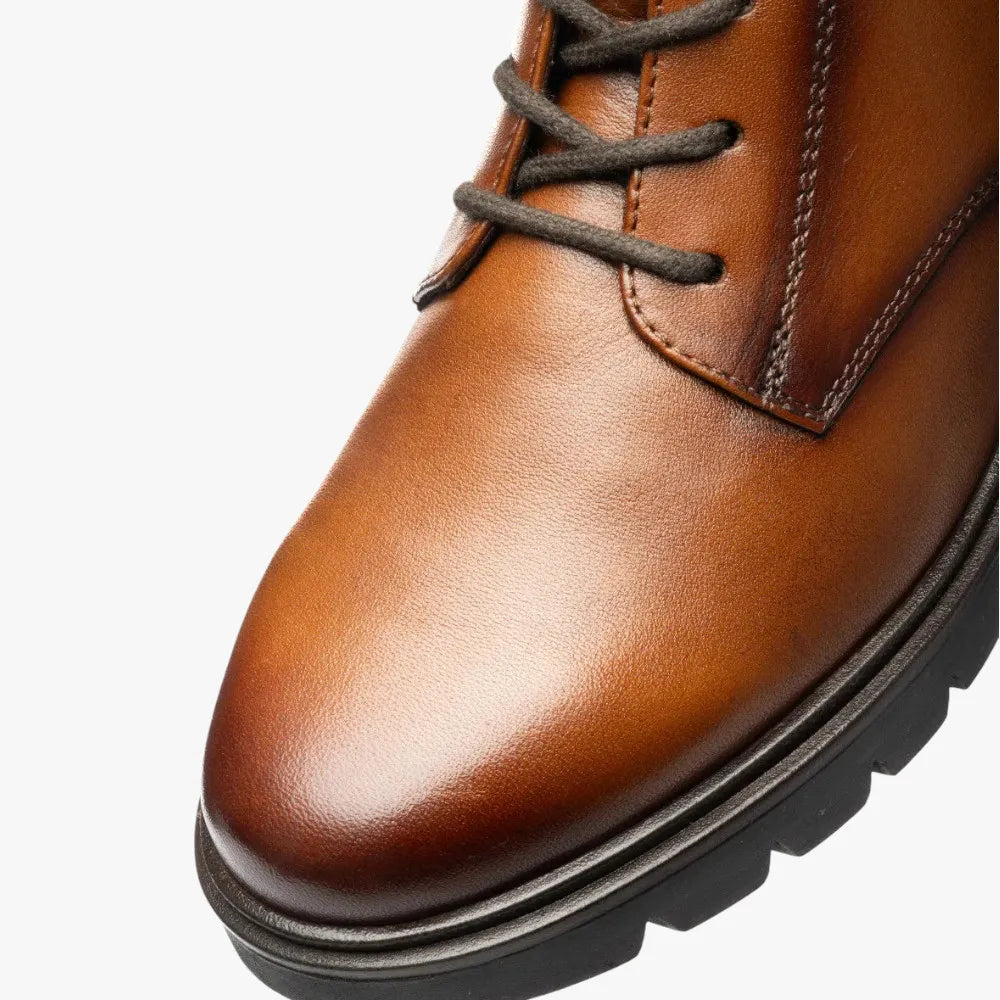 Close-up of a brown leather shoe with a white background