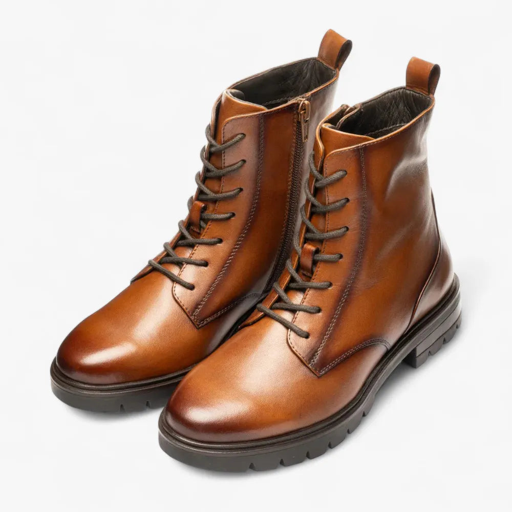 Pair of brown leather boots with laces on a white background