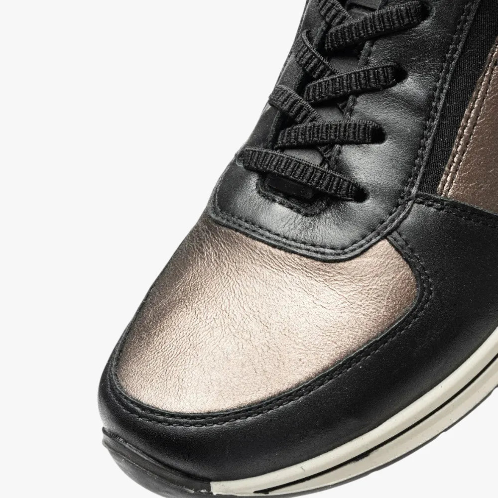 Close-up of a black and silver sneaker with laces on a white background