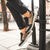 Person wearing black and brown sneakers on a city street.