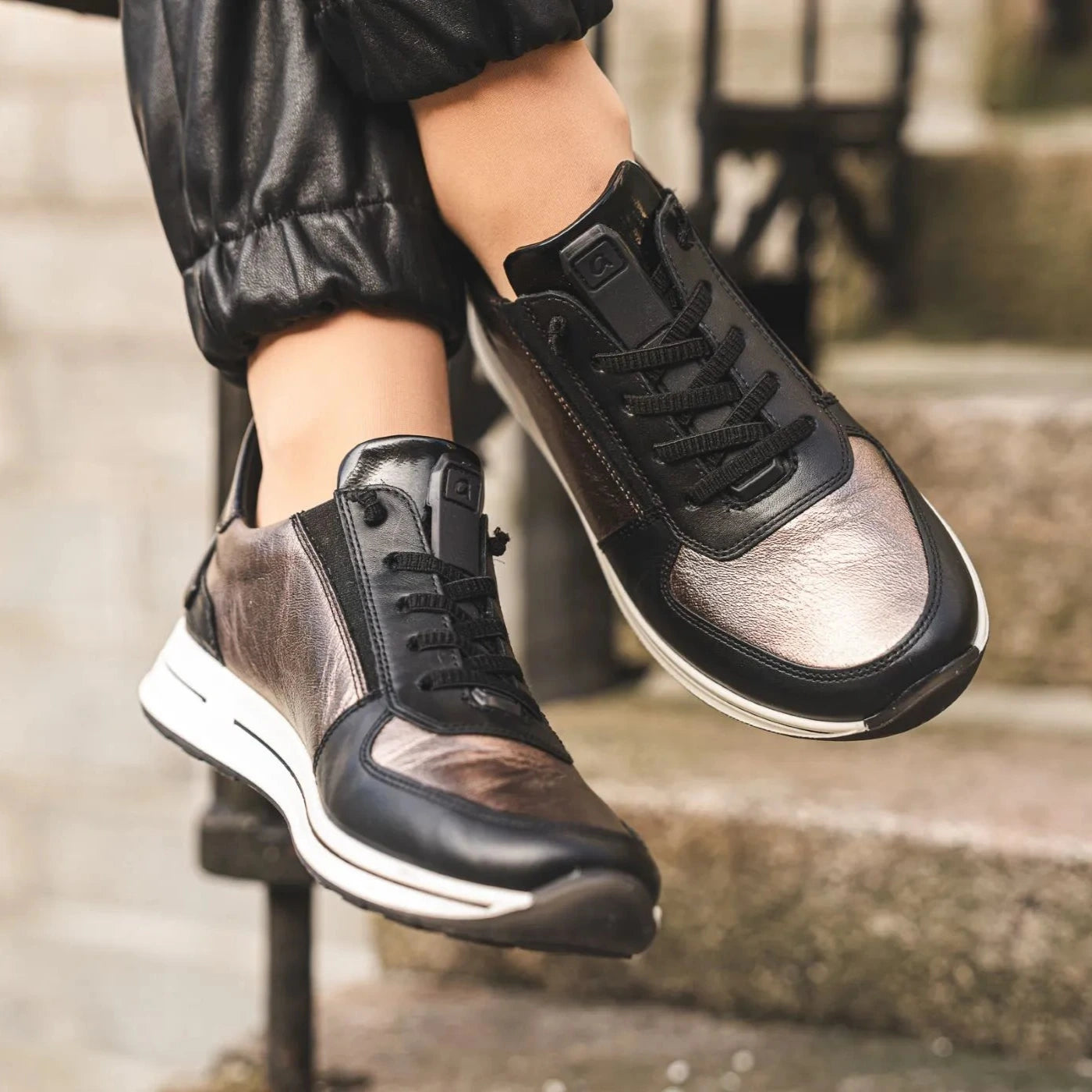 Black and brown sneakers on a person's feet with a blurred background