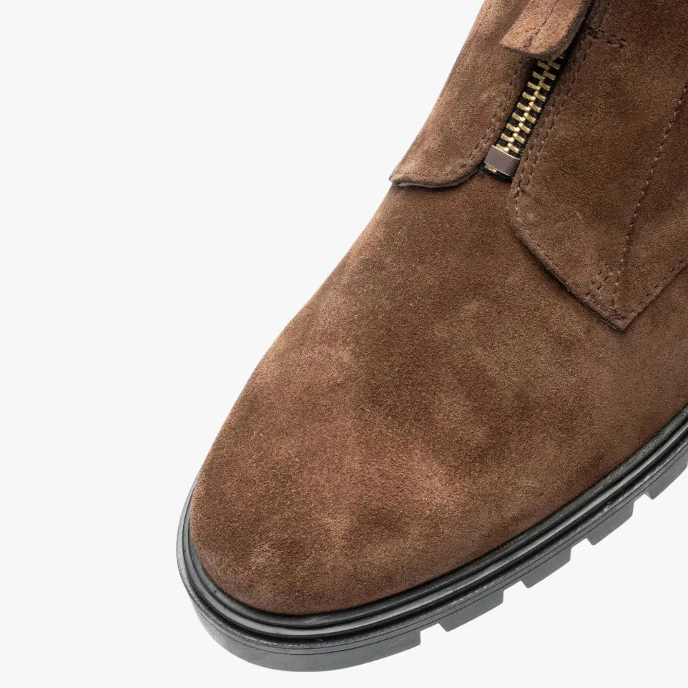 Brown suede shoe with a gold zipper on a white background