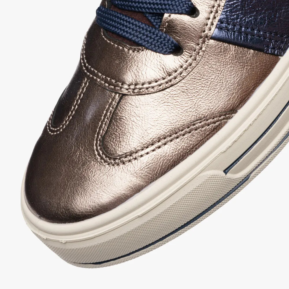 Close-up of a metallic bronze sneaker with blue laces on a white background
