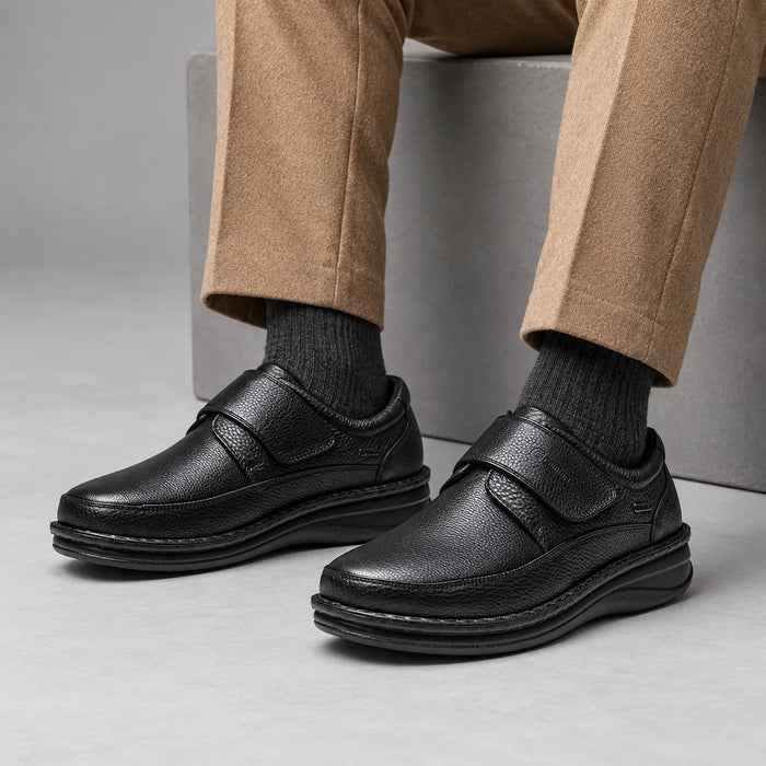 G-Comfort P-3708 men's black extra-wide strap shoes styled with camel trousers and charcoal socks in a grey studio.
