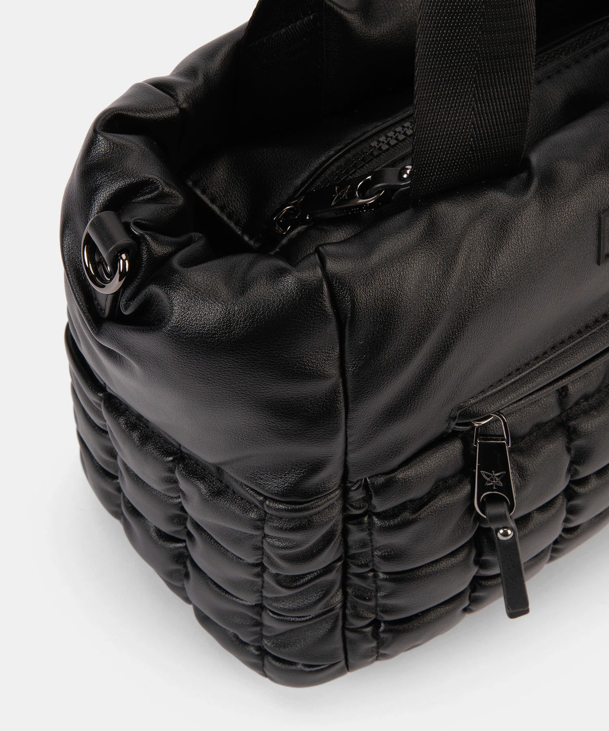 Black quilted bag with zippers on a white background