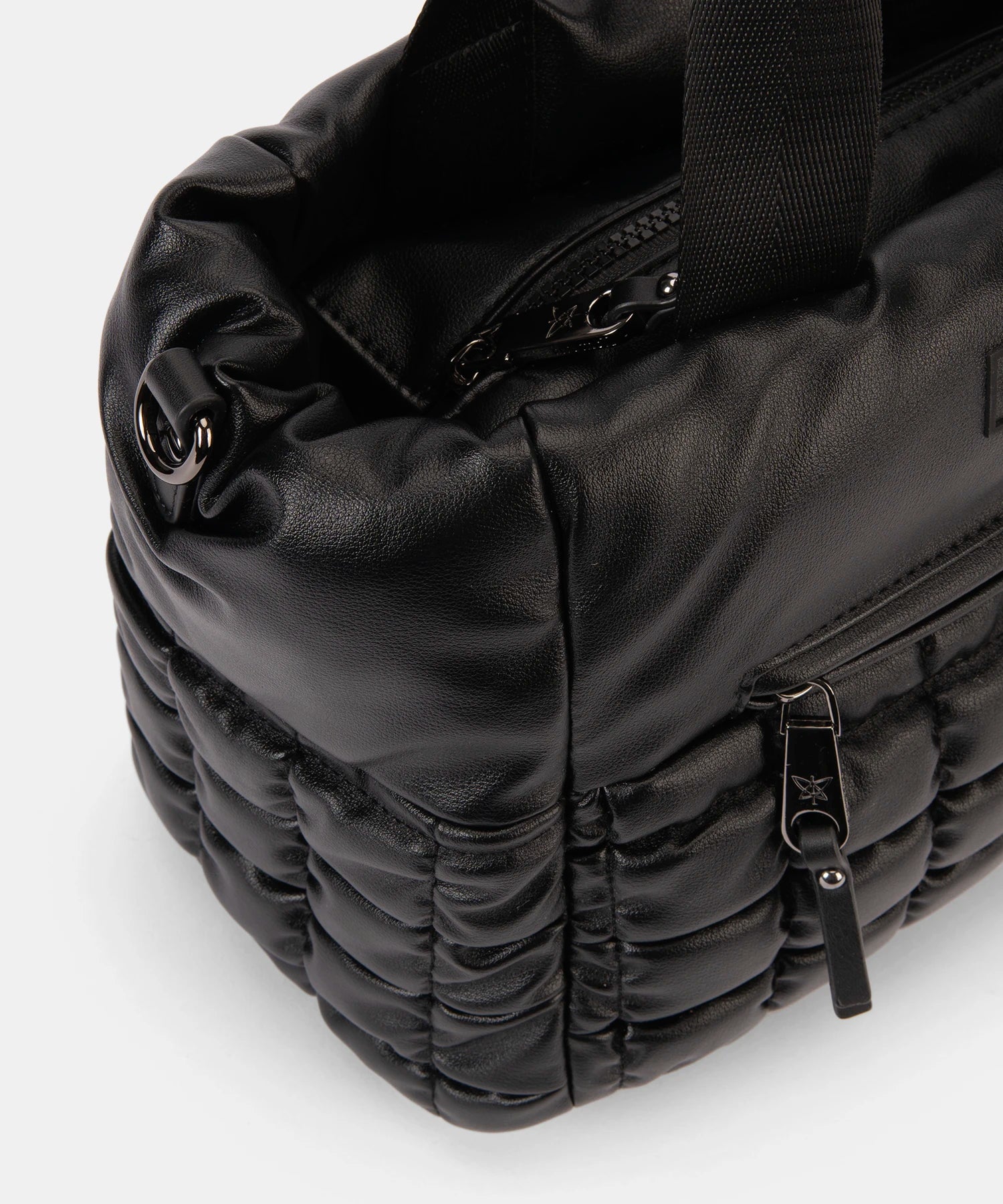 Black quilted bag with zippers on a white background