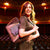 Woman holding a large pink clutch in an auditorium