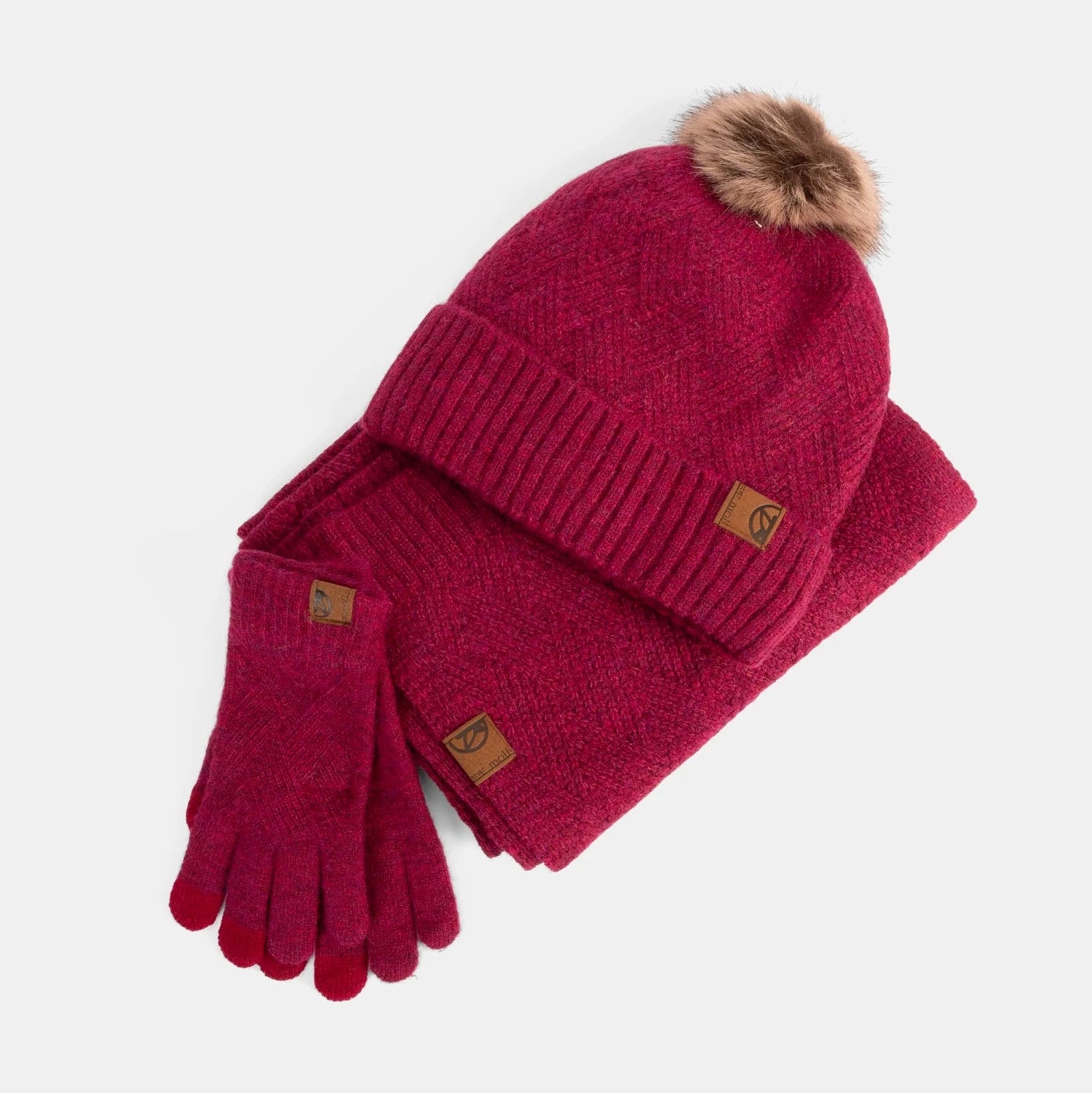 Red knit hat and gloves set with fur pom-pom on a light gray background