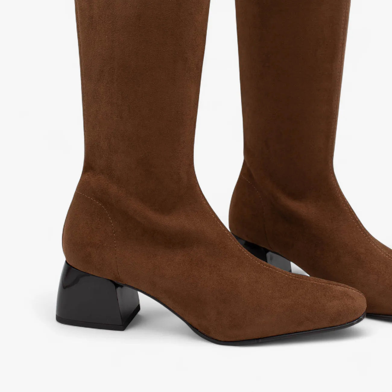 Brown knee-high boots with black block heels on a white background