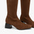 Brown knee-high boots with black block heels on a white background