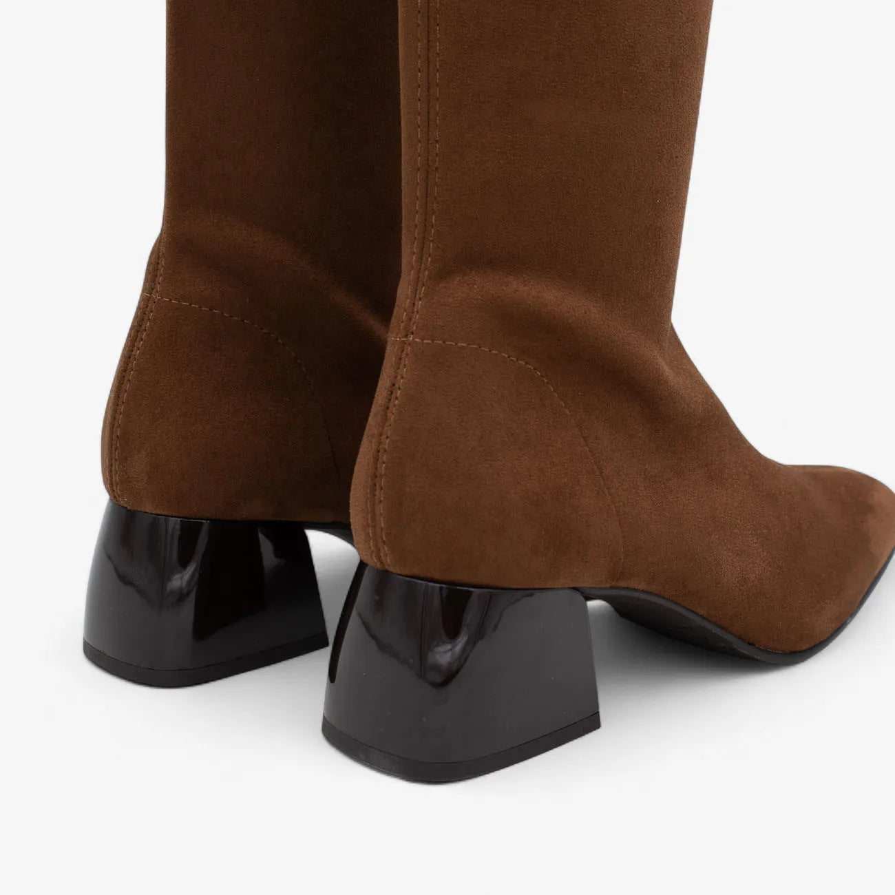 Brown knee-high boots with black block heels on a white background