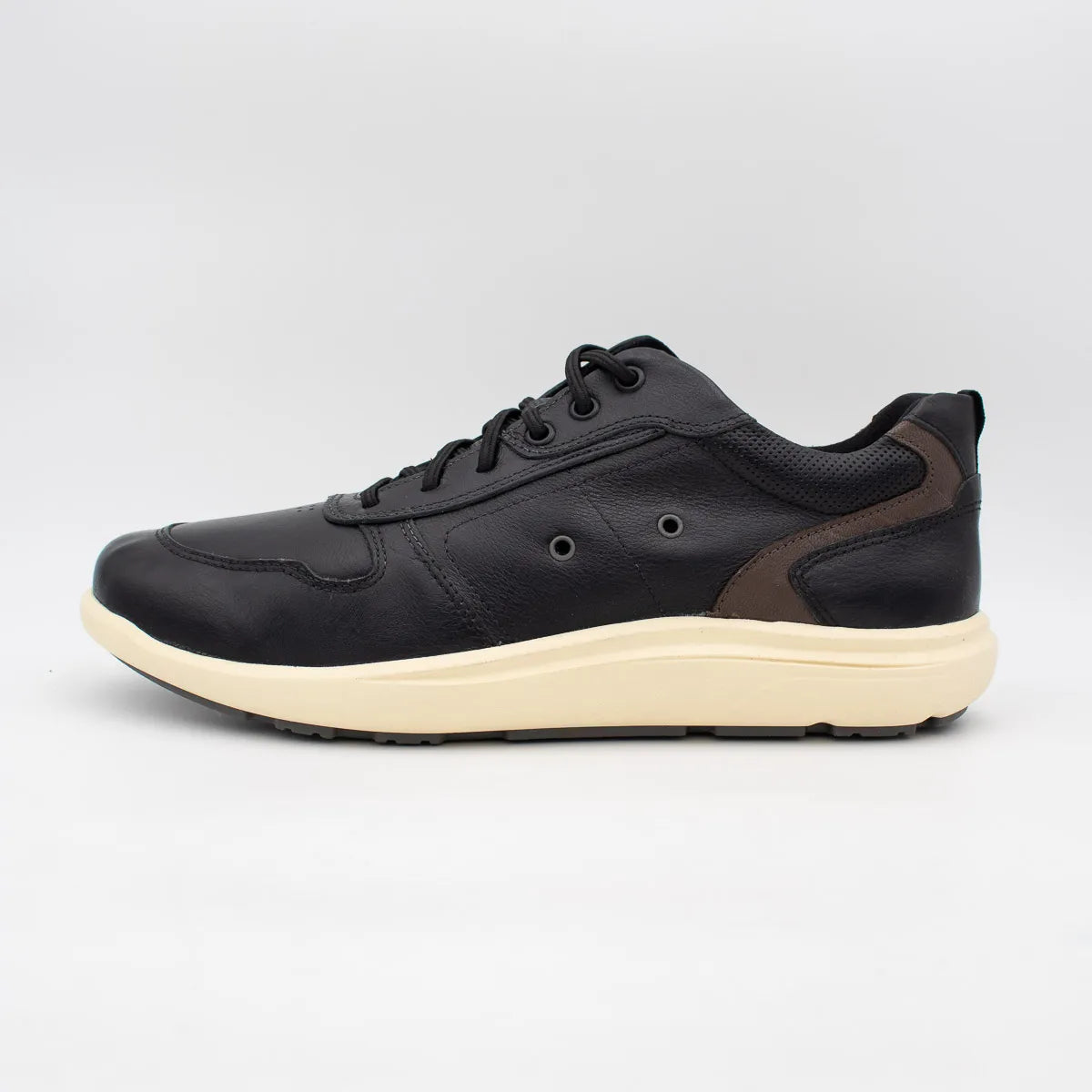 Black sneaker with a white sole on a light grey background