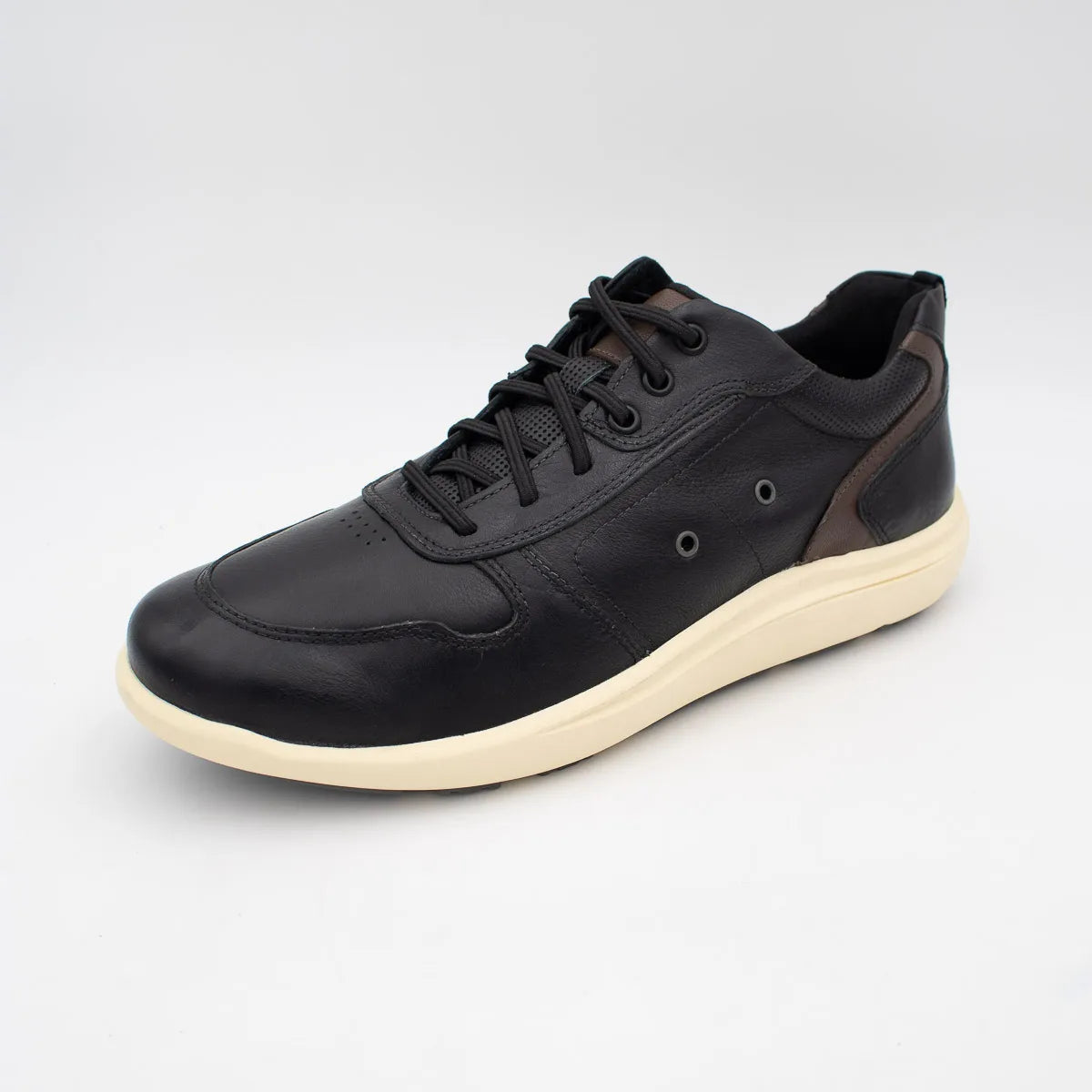 Black sneaker with white sole on a light grey background