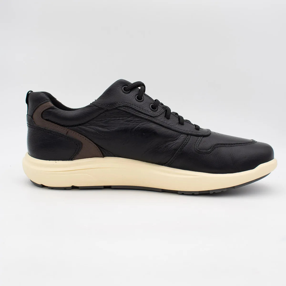 Black leather sneaker with a white sole on a light grey background