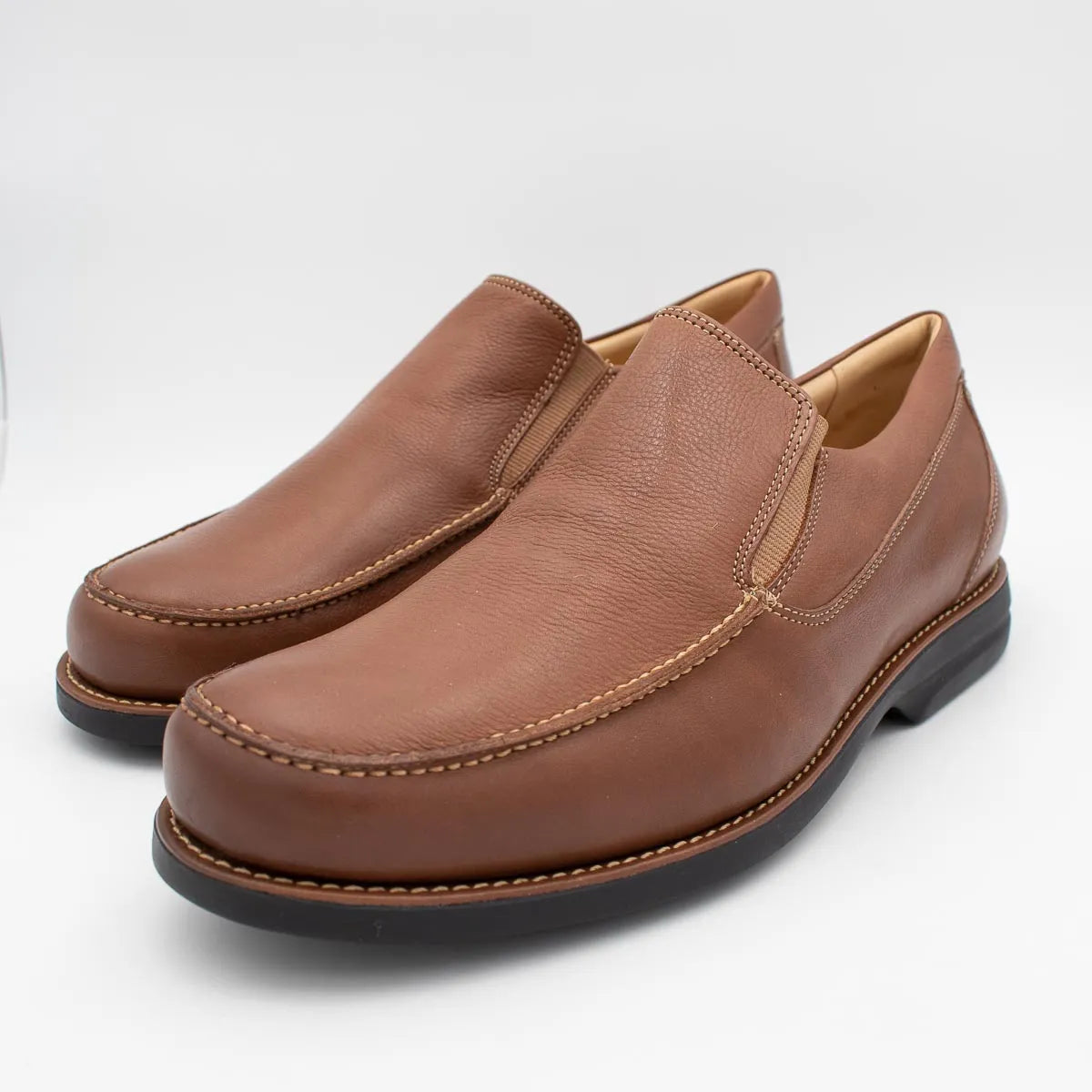 Pair of brown leather loafers on a white background