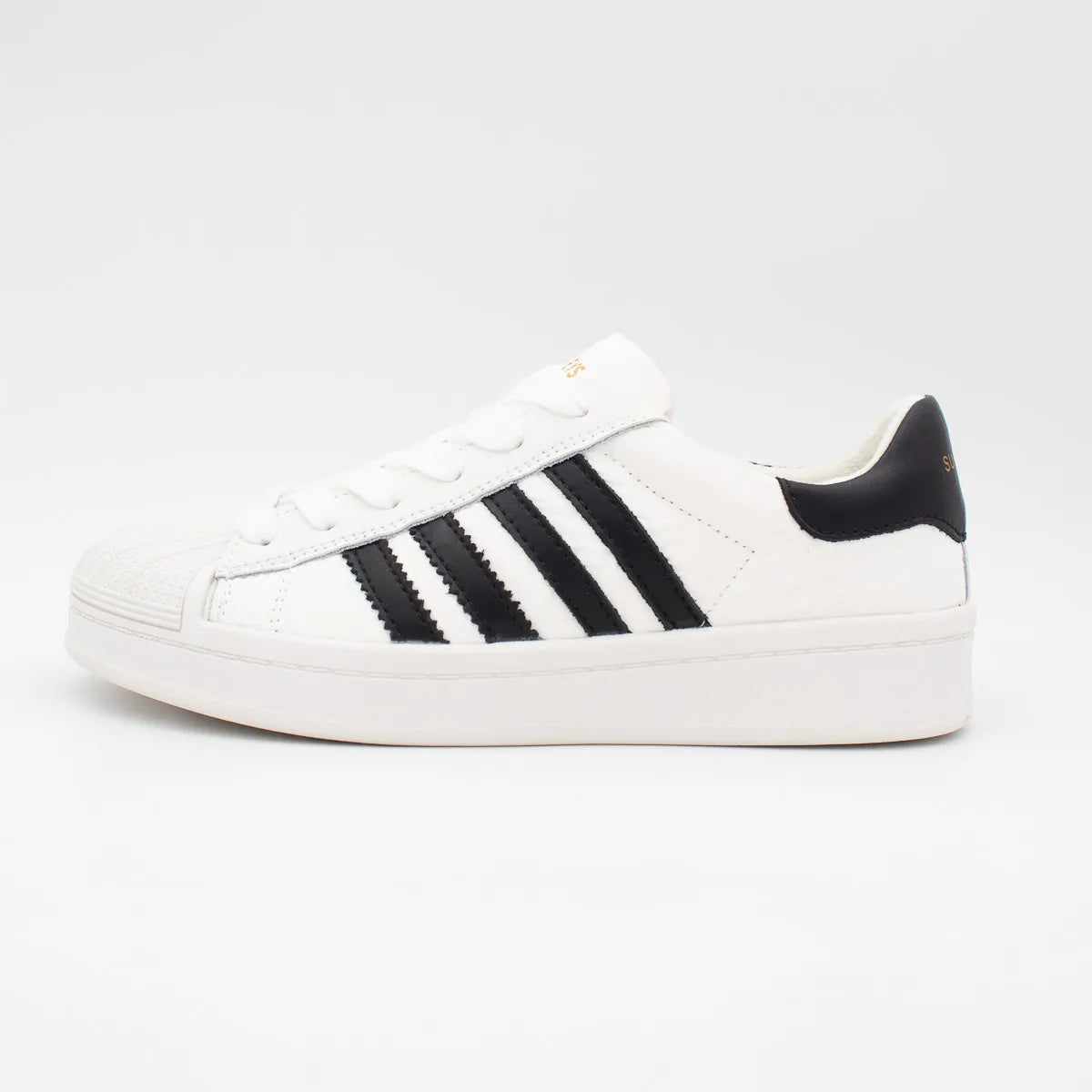 White sneaker with black stripes on a light gray background