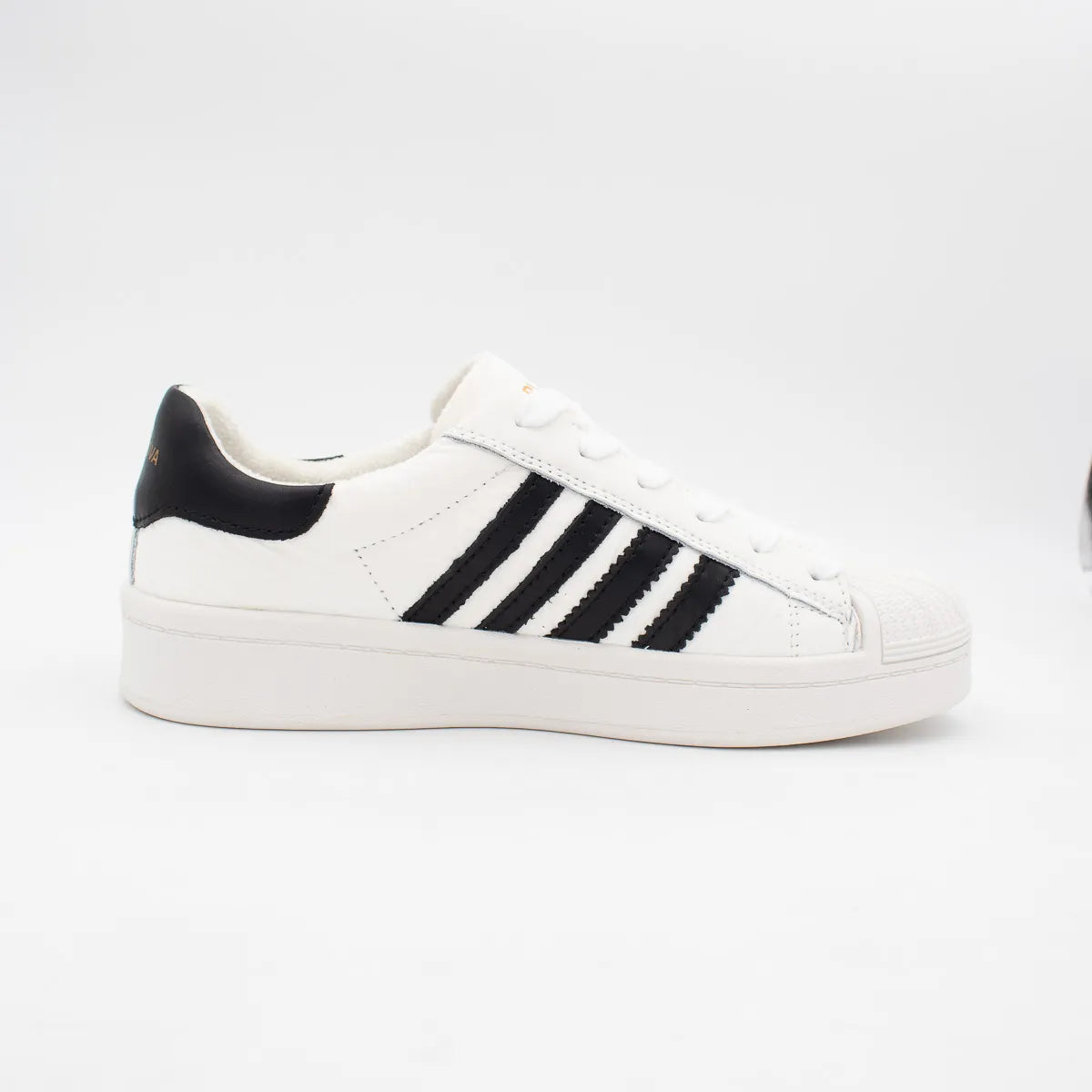 White sneaker with black stripes on a white background