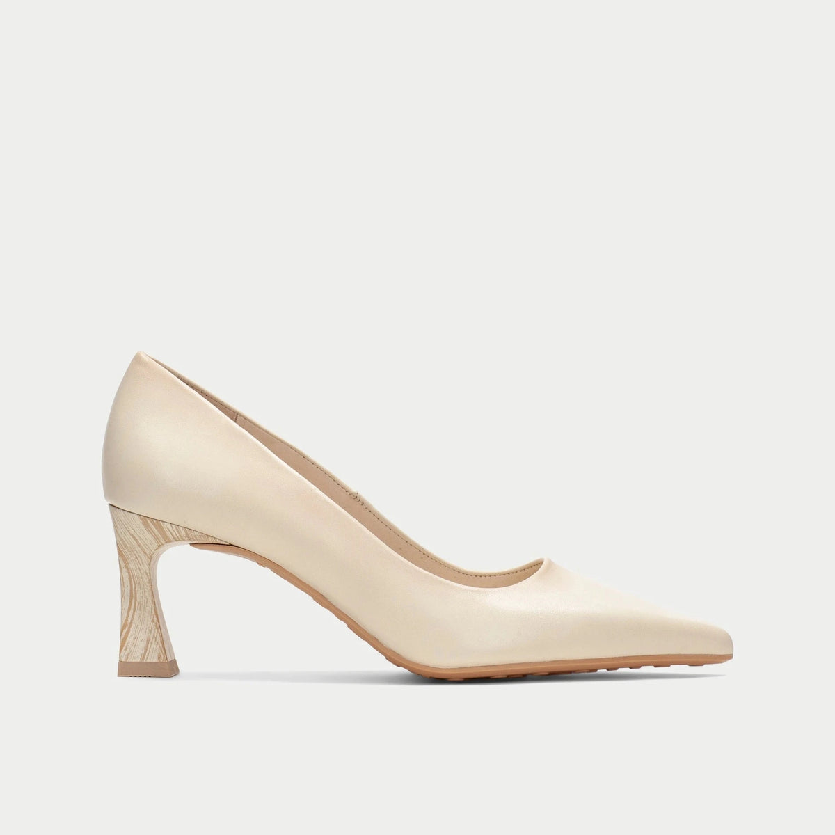 Beige high-heeled shoe on a light beige background