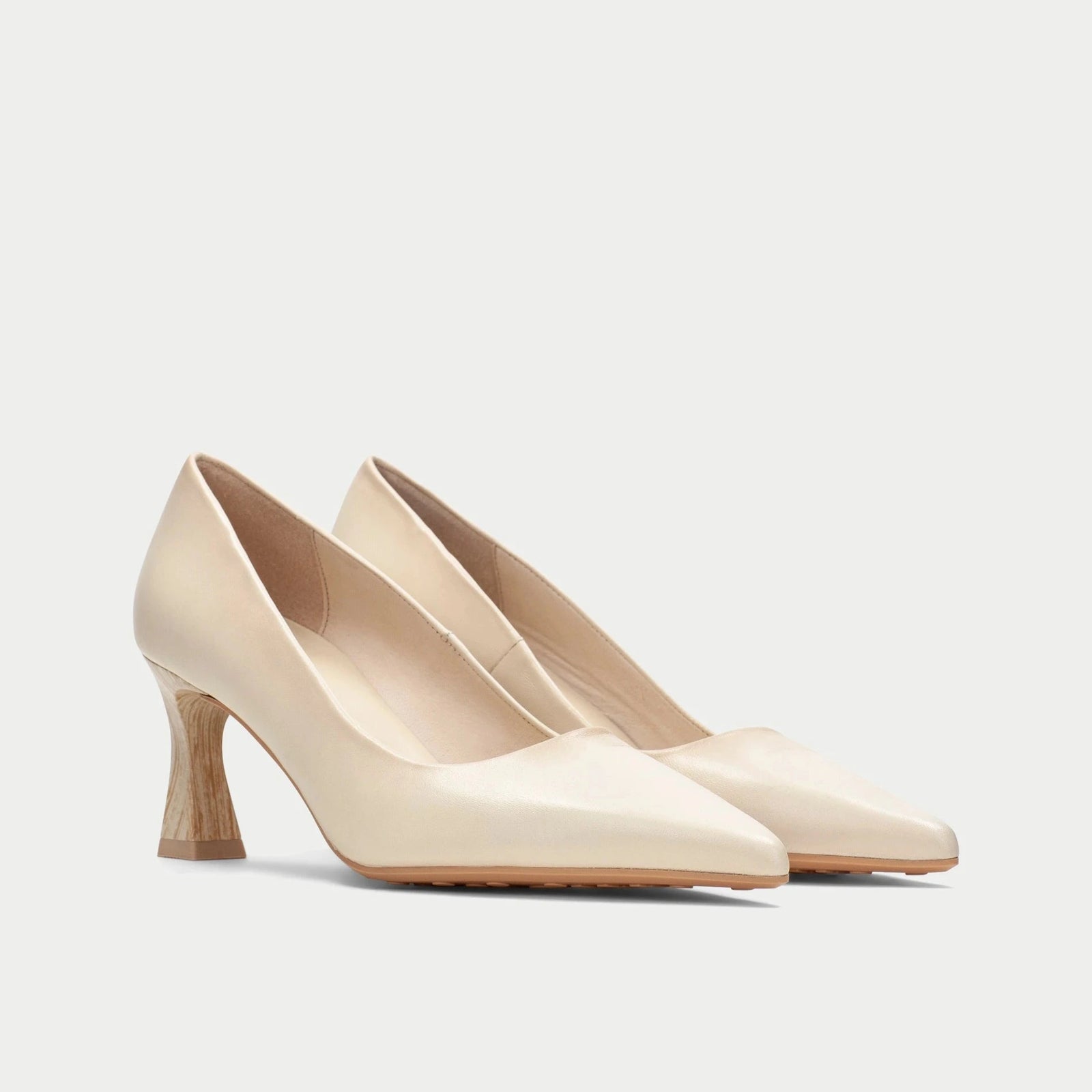 Pair of beige high-heeled shoes on a light gray background